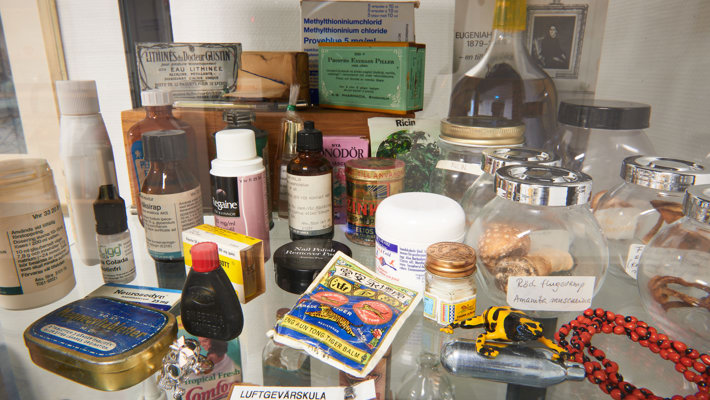 Många giftiga föremål i ett glasskåp , till exempel en lustgaspatron, torkad flugsvamp och en liten gulsvart groda. 