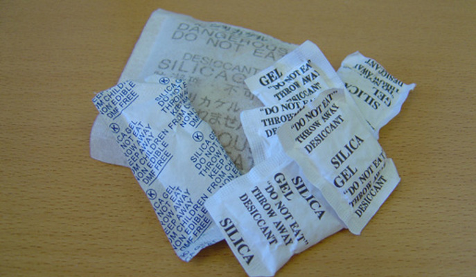 Påsar med Silica Gel ligger på ett bord.